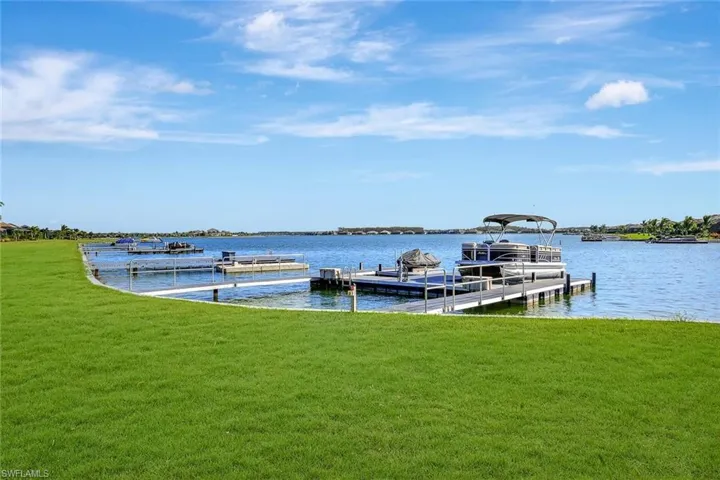View of dock with a water view and a yard