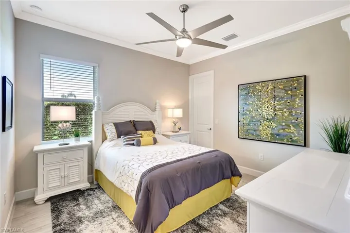 Bedroom with light wood-type flooring, ceiling fan, and ornamental molding