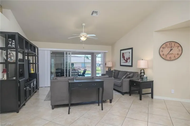 Tiled living room featuring ceiling fan and lofted ceiling