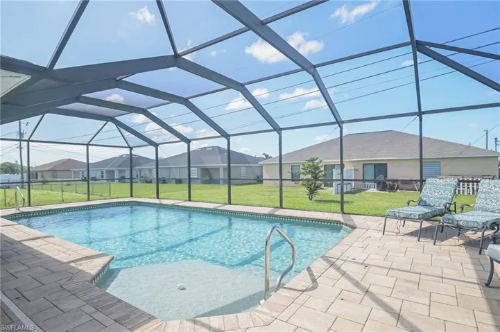 View of swimming pool featuring a patio, a lanai, and a lawn