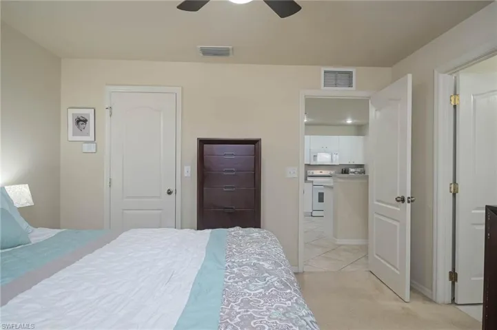 Bedroom with light colored carpet and ceiling fan