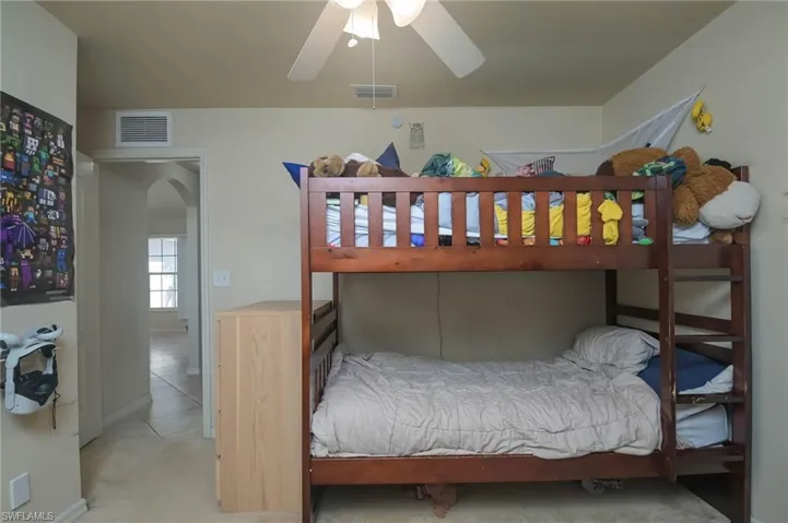 Bedroom with light colored carpet and ceiling fan