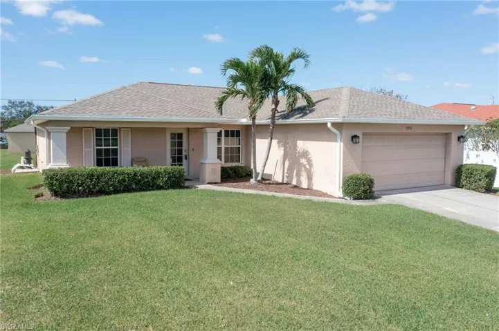 Single story home with a front yard and a garage