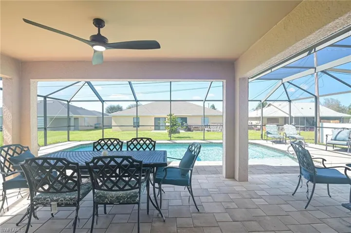 View of patio with glass enclosure and ceiling fan