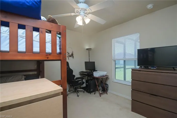 Carpeted bedroom featuring ceiling fan
