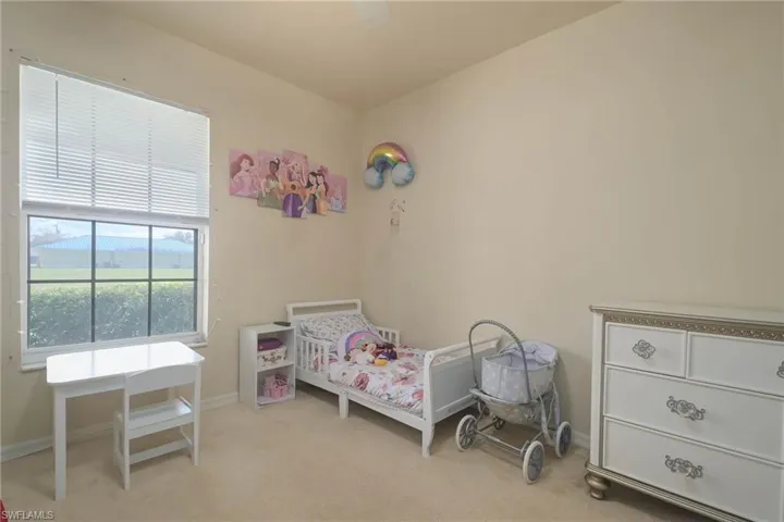 Carpeted bedroom featuring ceiling fan