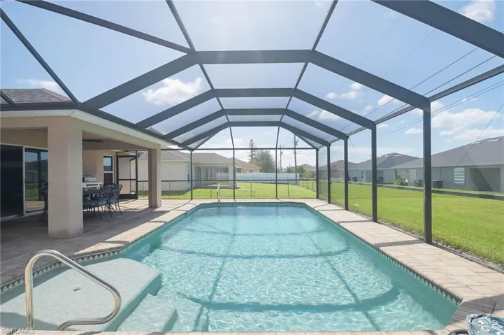 View of pool with a patio area, a lanai, and a lawn