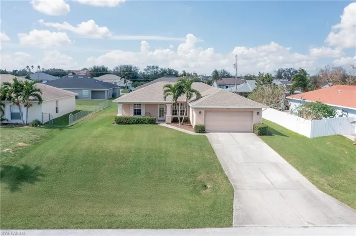 Single story home featuring a front yard and a garage