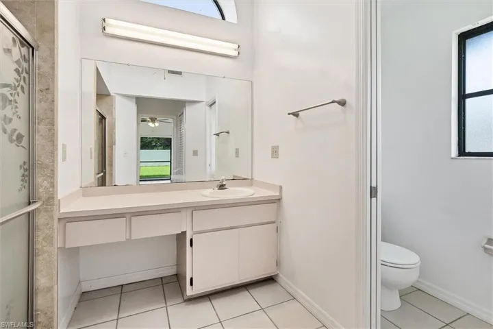 Bathroom featuring ceiling fan, vanity, toilet, and tile patterned flooring