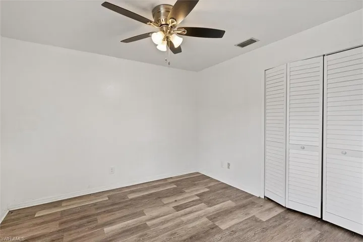Unfurnished bedroom featuring ceiling fan, hardwood / wood-style floors, and a closet