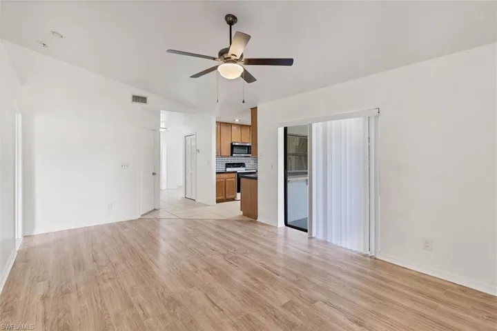 Tiled empty room featuring ceiling fan and lofted ceiling