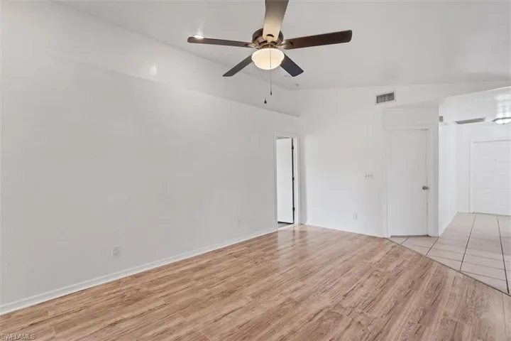 Unfurnished room featuring ceiling fan, lofted ceiling, and light hardwood / wood-style floors