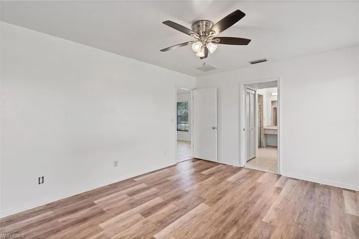 Empty room with ceiling fan and light hardwood / wood-style floors