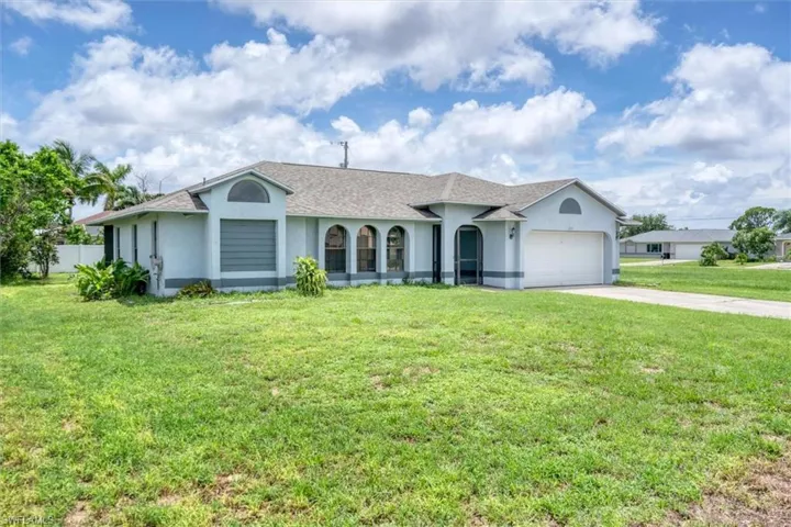 Ranch-style home featuring a garage and a front yard