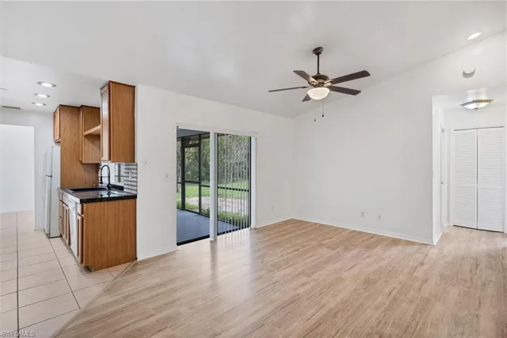 Kitchen with ceiling fan, white refrigerator, sink, and light hardwood / wood-style floors