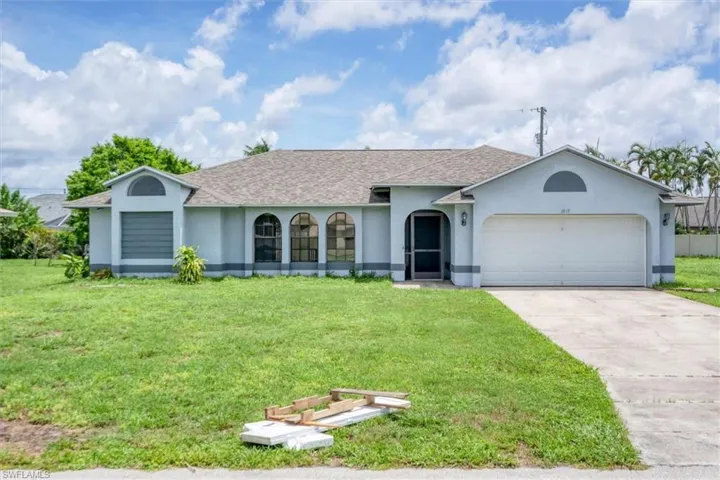 Ranch-style house with a garage and a front yard