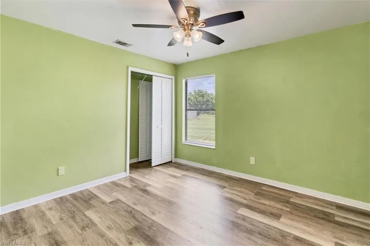 Unfurnished bedroom with ceiling fan, light wood-type flooring, and a closet