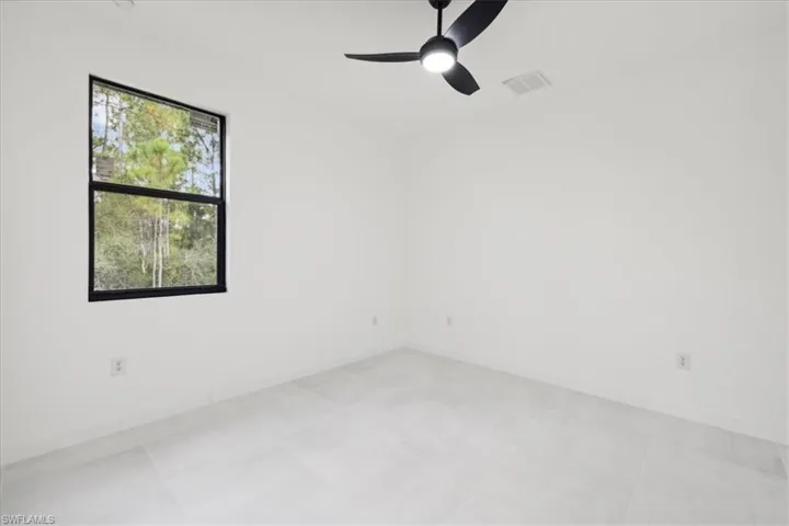 Spare room featuring ceiling fan and baseboards