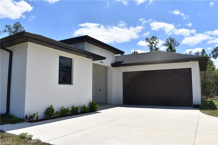 Contemporary stucco exterior with dark trim and a dark asphalt shingle roof