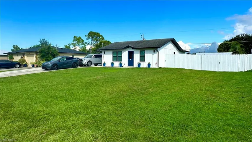 Fresh exterior paint, blue door, and modern curb appeal. 12-ft access gate for boats, trailers, or recreational vehicles.