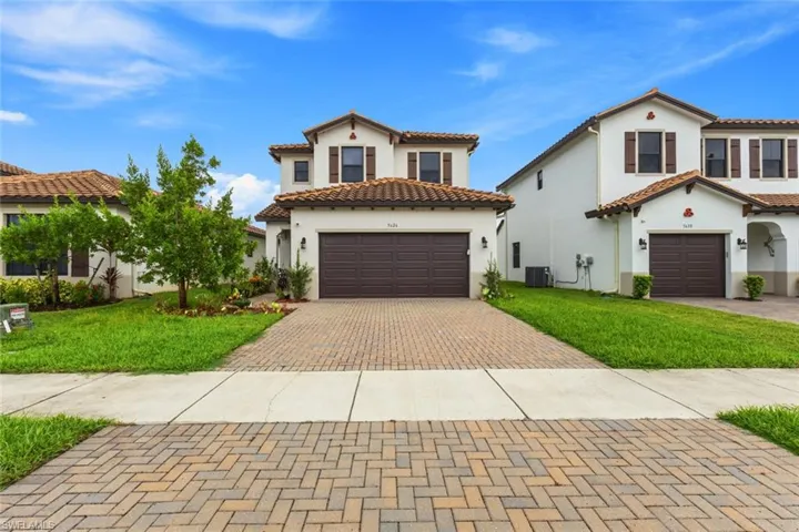Mediterranean / spanish-style house with stucco siding, a front lawn, decorative driveway, and a tile roof