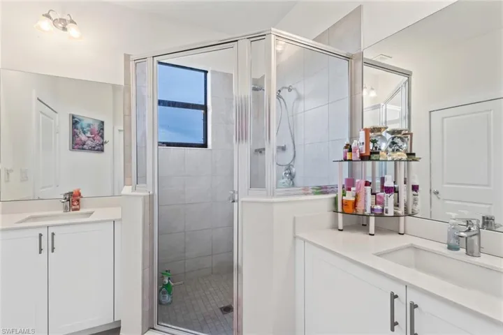 Bathroom with two vanities and a stall shower