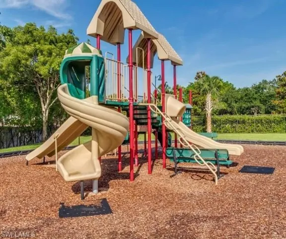 Community playground featuring multiple slides, climbing structures, and a wood chip safety surface