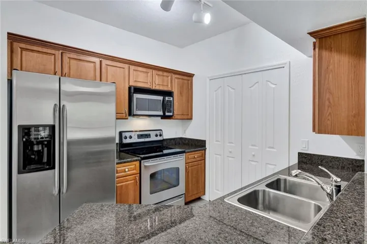Kitchen featuring double-basin stainless steel sink, new garbage disposal, and doors to the laundry with washer and dryer