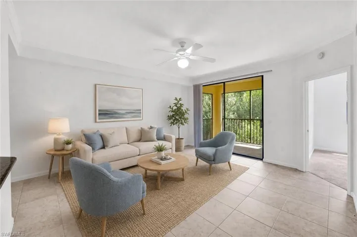 AI Staged neutral-toned tile flooring, crown molding, and a ceiling fan with light looking towards the lanai