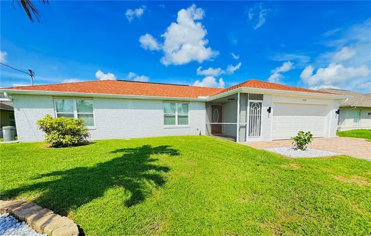 View of front facade with a garage and a front lawn