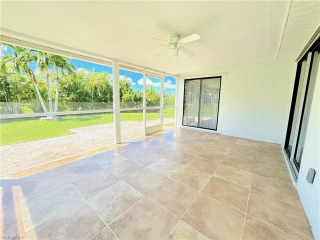 Screened in back lanai, ceiling fan, and tile floor