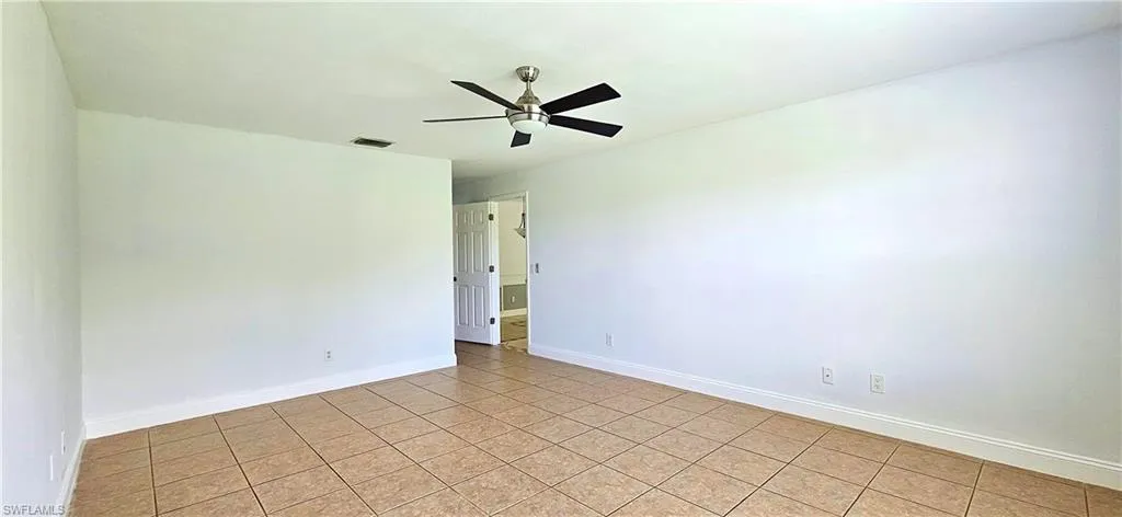 Tiled Primary bedroom with ceiling fan