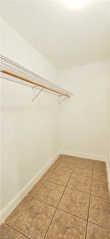 Walk in Primary closet with tile patterned floors