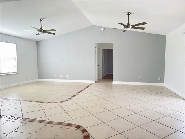 Living room featuring lofted ceiling, tile flooring, and 2 ceiling fans.
