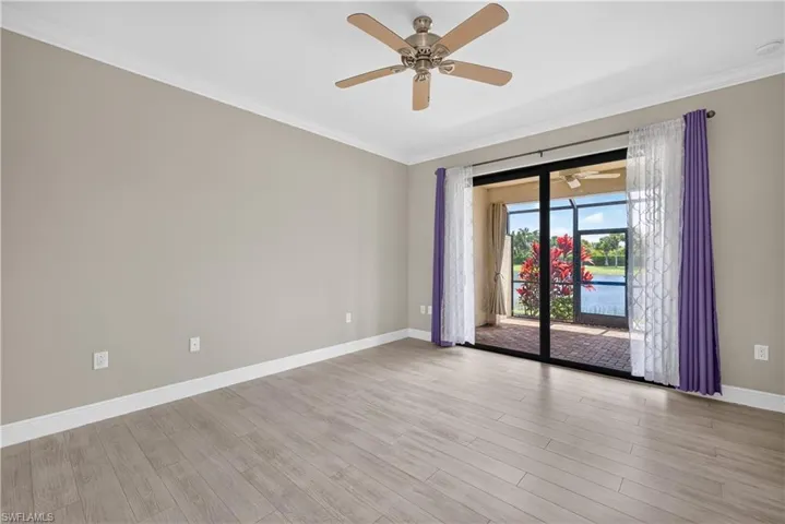 Spacious bedroom with  glass doors opening to a screened lanai and water views.