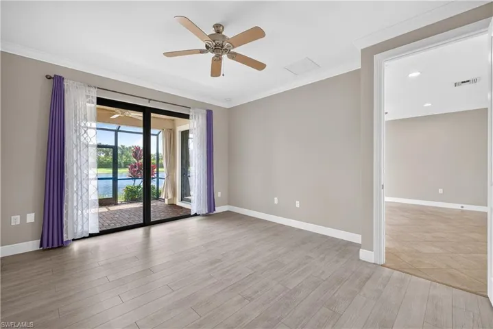 Expansive sliding glass doors open to a screened lanai with water and garden views