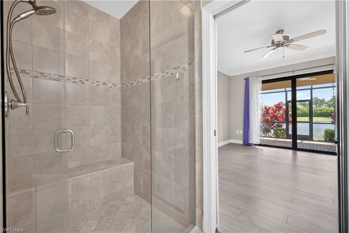 Walk-in shower with neutral-toned tiling and integrated bench seating