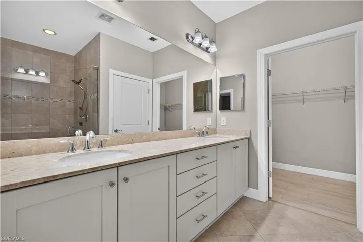 Dual vanity with undermount sinks, light-toned countertop, and light grey cabinetry
