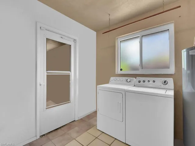 Laundry room featuring separate washer and dryer and light tile patterned floors
