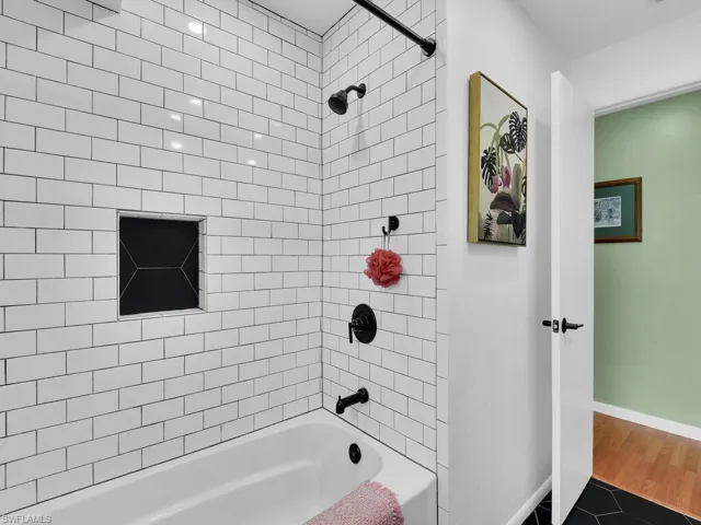 Bathroom featuring hardwood / wood-style flooring and tiled shower / bath