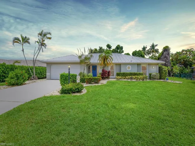 Single story home with a garage and a front lawn
