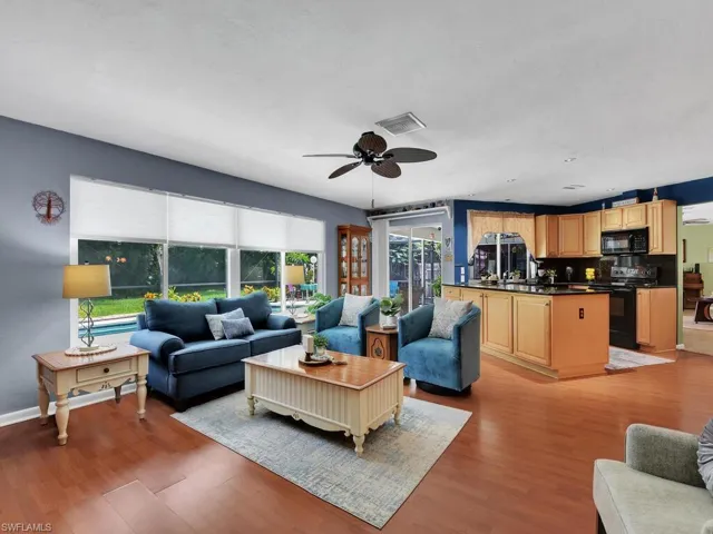 Living room with ceiling fan and light wood-type flooring