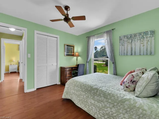 Bedroom with ceiling fan, a closet, and dark wood-type flooring