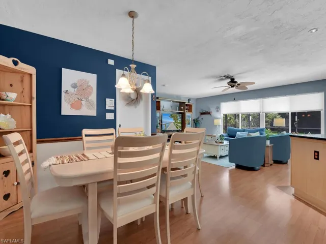 Dining room featuring ceiling fan with notable chandelier and light hardwood / wood-style flooring