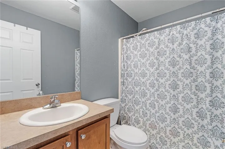 Bathroom with vanity, toilet, and shower/tub combo