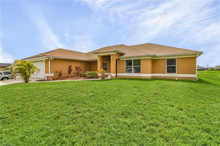 View of front of home featuring 2 car garage and a front yard