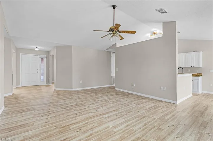 Unfurnished living room featuring high vaulted ceiling, ceiling fan, and light hardwood / wood-style flooring