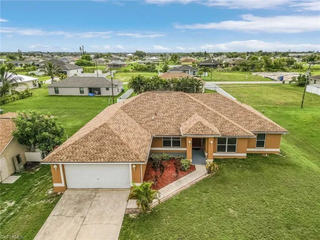 View of front of house with a garage and a front yard