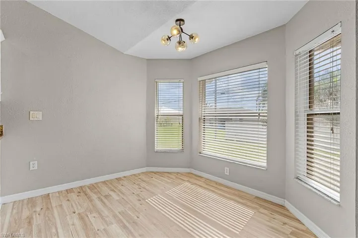 Breakfast nook with a chandelier and vinyl wood-type flooring