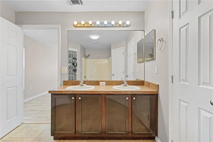Bathroom with tile flooring, large vanity, and double sink